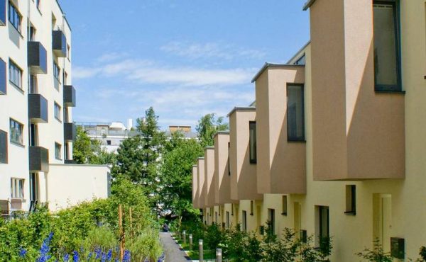 Moderne Wohnanlage in Wien mit hellen Fassaden und begrünten Außenbereichen. Ideal für Wohnung kaufen.