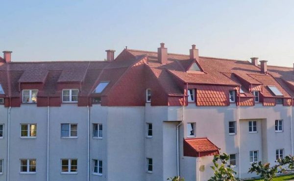 Moderne Wohnanlage mit roten Dächern in ruhiger Lage, ideal für Wohnungskauf.