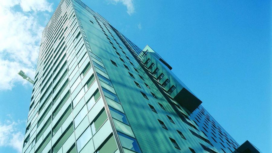 Hochmoderne Glasfassade eines Wolkenkratzers in urbaner Lage, perfekt zum Wohnung kaufen in Wien.