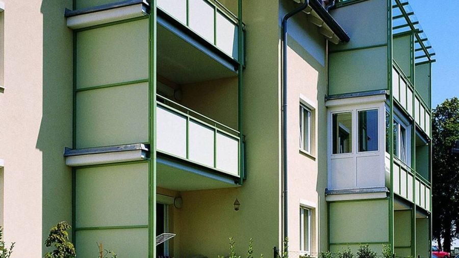 Modernes Mehrfamilienhaus mit grünen Balkonen in ruhiger Lage, ideal für Wohnungskäufer in Wien.