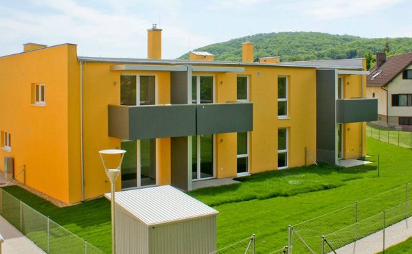 Modernes Mehrfamilienhaus in Wien mit grünem Garten und Balkon, ideal für Wohnungskäufer.