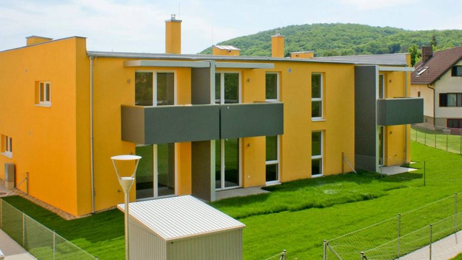 Modernes Mehrfamilienhaus in Wien mit grünem Garten und Balkon, ideal für Wohnungskäufer.