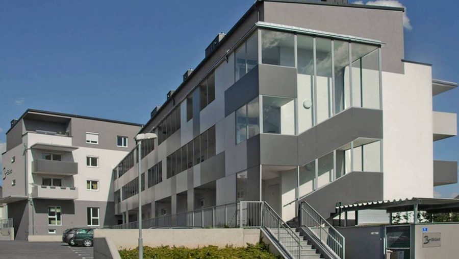 Moderne Wohnanlage in Wien mit großzügigen Fenstern und ansprechender Architektur für Immobilienangebote.