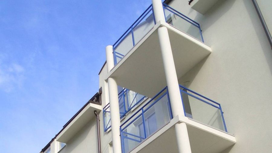 Balkone einer modernen Wohnung in Wien mit gläsernen Geländern und blauer Umrandung. Ideal für Wohnungskäufer.