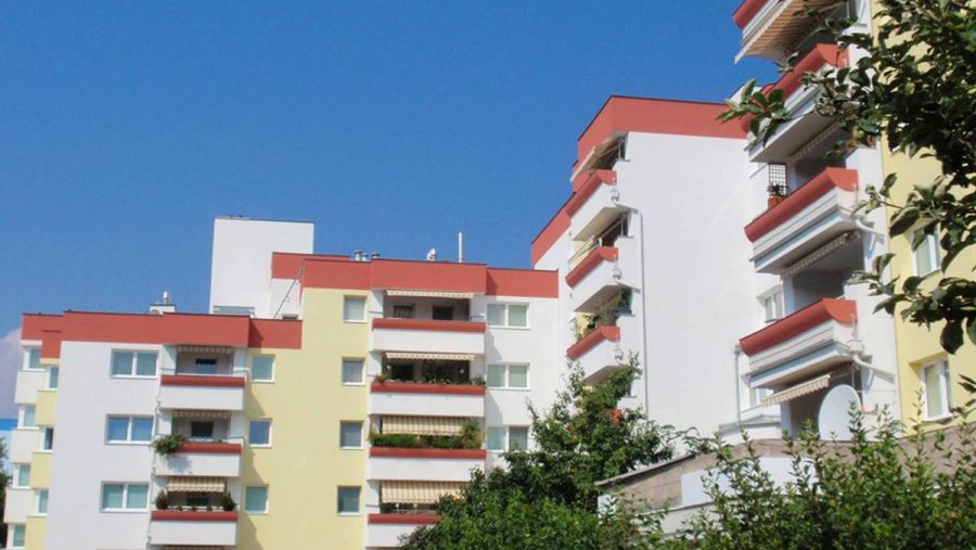 Moderne Wohnanlage mit mehreren Etagen und Balkonen in Wien, ideal für Wohnungskäufer.