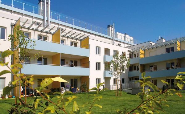 Modernes Wohngebäude mit Balkonen und Gartenfläche in Wien, ideal für Wohnungskäufer.