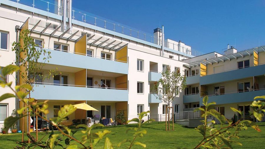 Modernes Wohngebäude mit Balkonen und Gartenfläche in Wien, ideal für Wohnungskäufer.