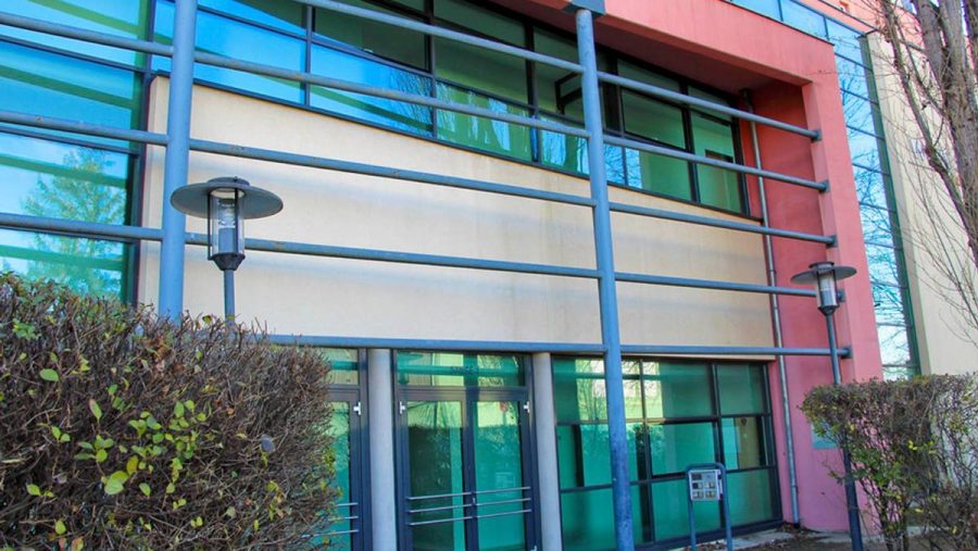 Moderne Gewerbefassade mit großen Fenstern in urbaner Umgebung. Büros zu kaufen in Wien.