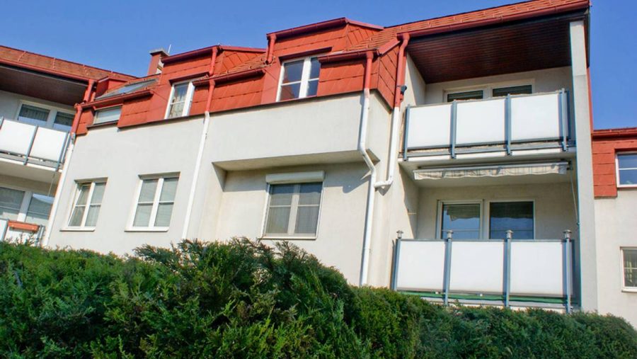 Moderne Wohnung mit Balkon und rotem Dach, ideal zum Kaufen in Wien.