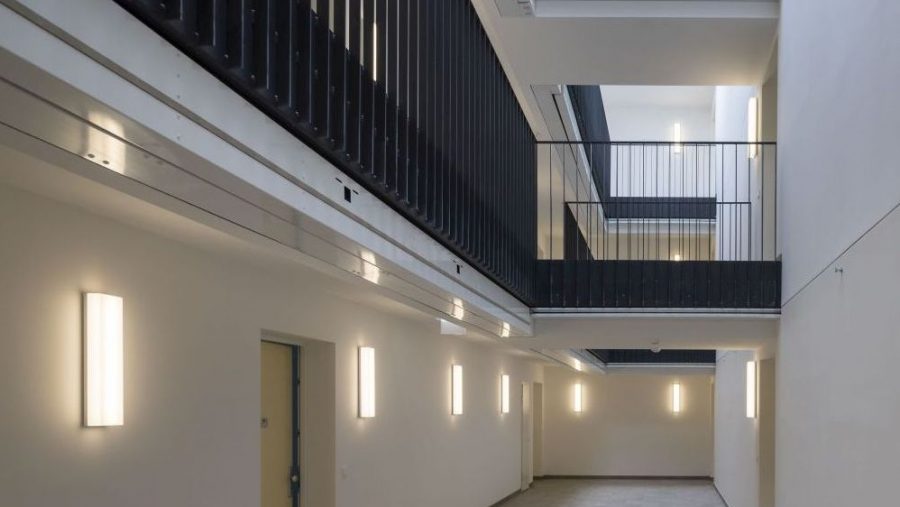 Moderner Innenbereich eines Gebäudes mit beleuchteten Wänden und Metallgeländern.