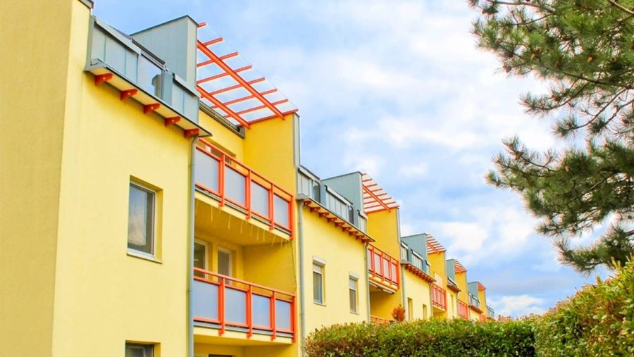 Moderne gelbe Wohnungen mit Balkonen in ruhiger Lage, ideal für Wohnungskauf in Wien.