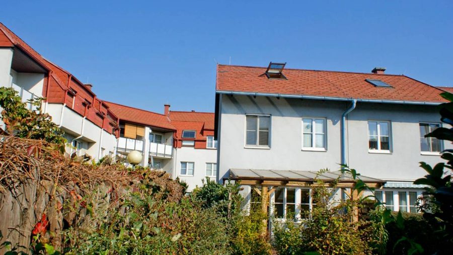 Blick auf ein modernes Haus mit Garten in einer ruhigen Wohnlage, ideal für Immobilienkäufer in Wien.