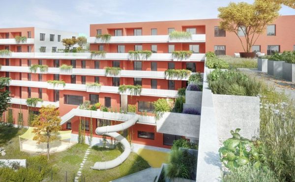 Rote Wohnanlage mit Balkonen und viel Grün, moderne Architektur, Stadtansicht bei Tag.