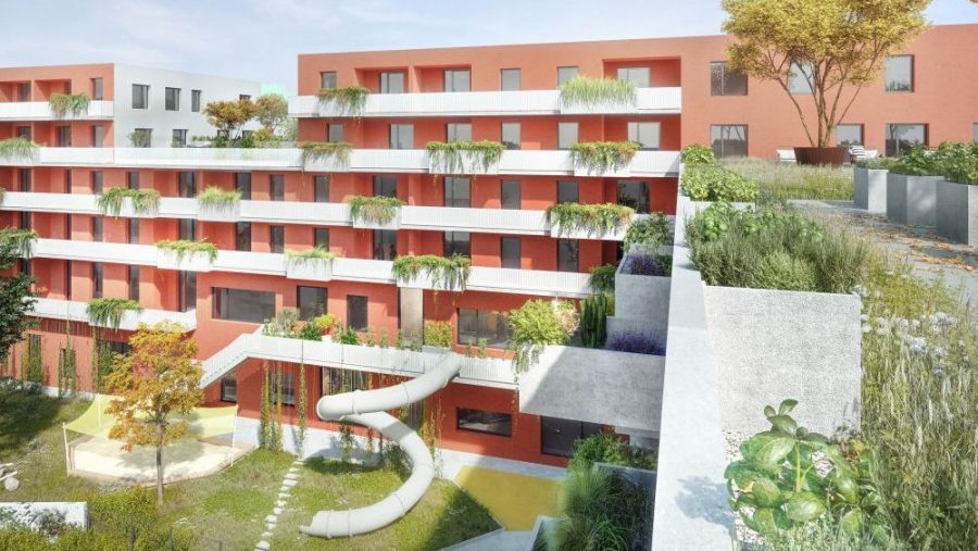 Rote Wohnanlage mit Balkonen und viel Grün, moderne Architektur, Stadtansicht bei Tag.