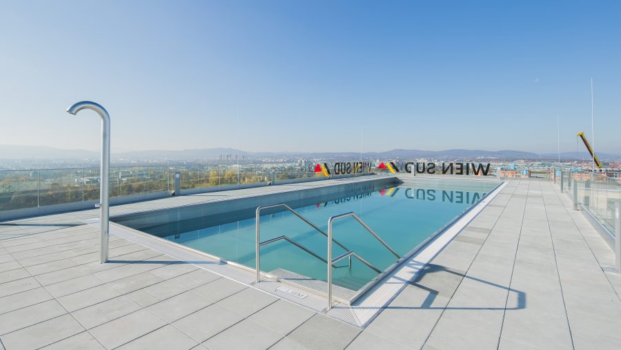 Moderner Dachpool mit Ausblick über die Stadt bei klarem Himmel.