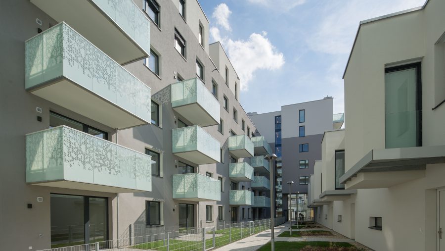 Moderne Wohnungen mit Glasbalkonen und gepflegtem Gartenweg. Ideal für urbanes Wohnen in Wien.