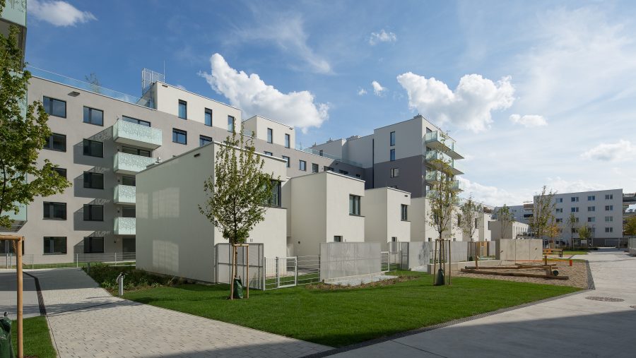 Moderne Wohnanlage mit Balkonen und Grünfläche in urbaner Umgebung. Ideal für Wohnungskauf in Wien.