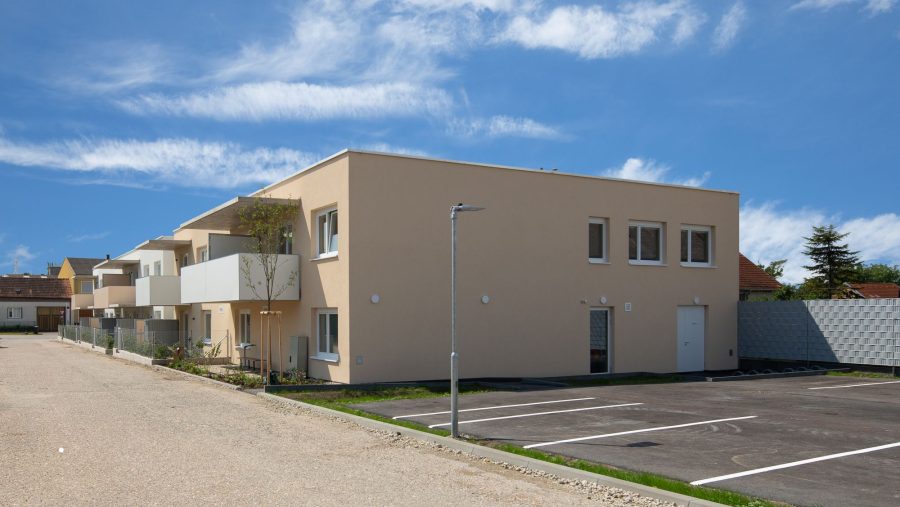 Modernes Wohngebäude mit Balkonen bei sonnigem Wetter, Ansicht von der Straße.