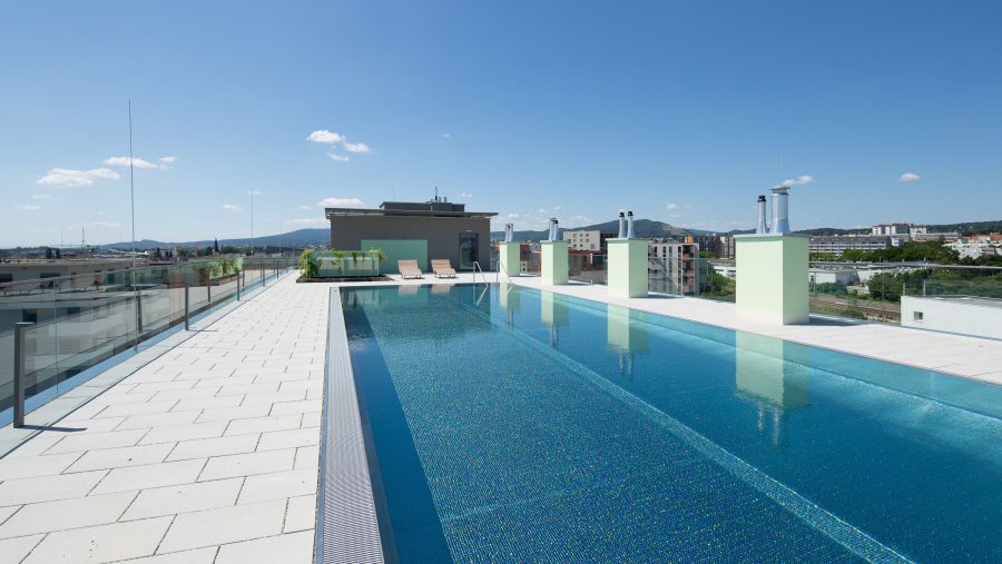 Dachterrassenpool mit Stadtblick an einem sonnigen Tag.