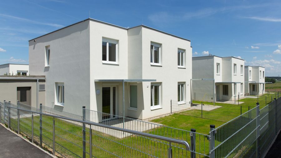 Moderne Doppelhaushälften mit Garten und Zaun im Grünen. Ideal für Familien.