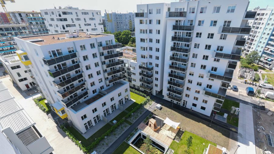 Moderne Wohngebäude mit Balkonen und Dachterrassen in einer urbanen Umgebung.