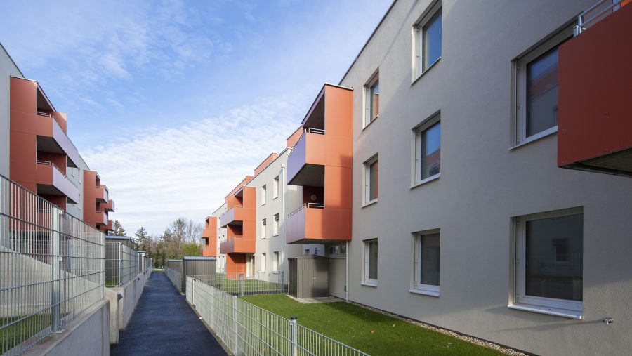 Moderne Wohngebäude mit Balkonen und blauem Himmel im Hintergrund.