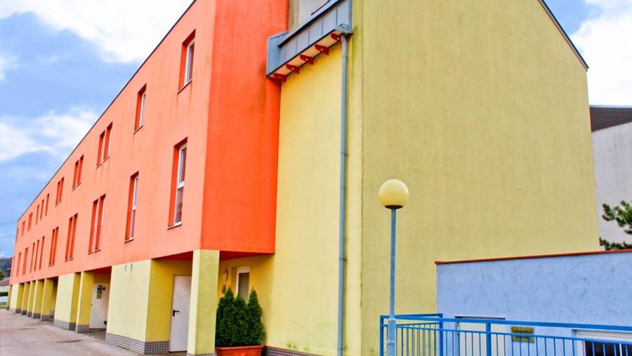 Mehrfamilienhaus mit bunter Fassade in urbaner Lage.