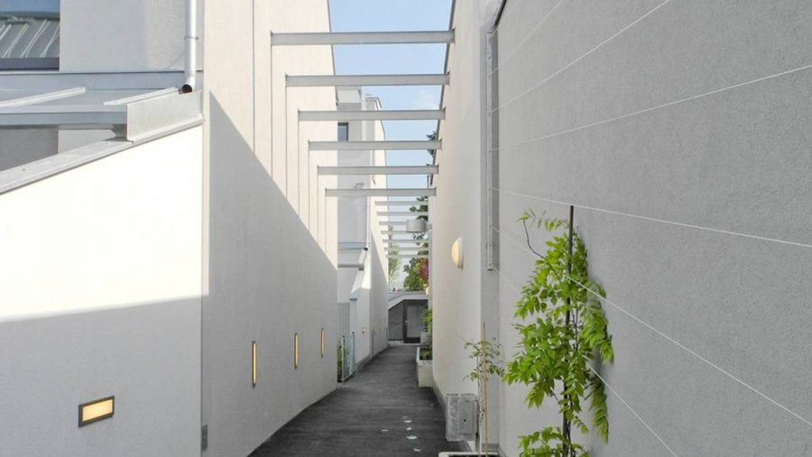 Moderner Durchgang zwischen Gebäuden mit Pflanzen, ideal für eine Wohnung in Wien.