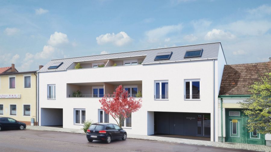 Mehrfamilienhaus mit modernem Design und Balkonen, umgeben von Autos und Bäumen in einer Stadtstraße.