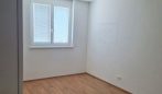 Leeres Zimmer mit Holzboden und Fenster, ideal für Büro oder Kinderzimmer. Perfekt für Immobilienangebote.