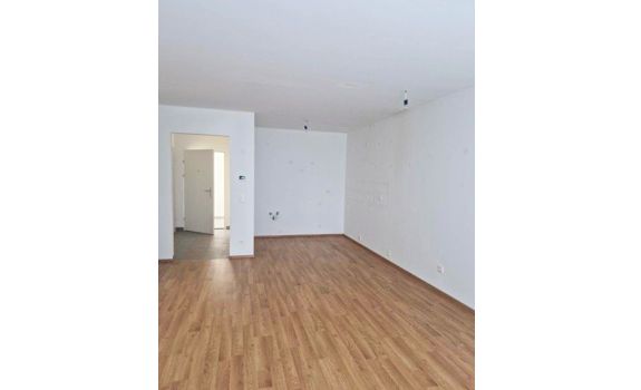 Leerer Wohnraum mit Holzboden in moderner Wohnung.