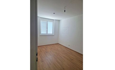 Helles Zimmer mit Holzboden und Fenster, ideal als Schlafzimmer in einer Wiener Wohnung.