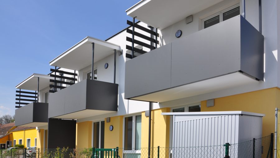 Moderne Stadthäuser mit Balkonen unter blauem Himmel.