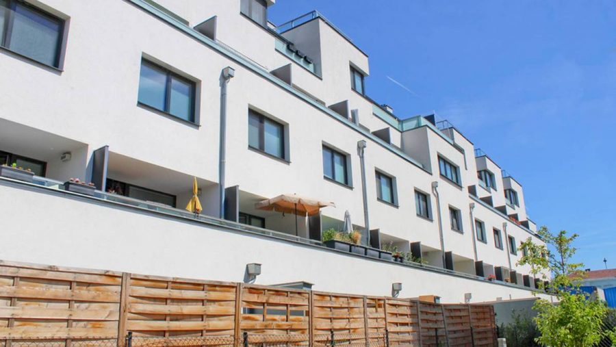 Moderne Wohnanlage mit Balkonen an einem sonnigen Tag.