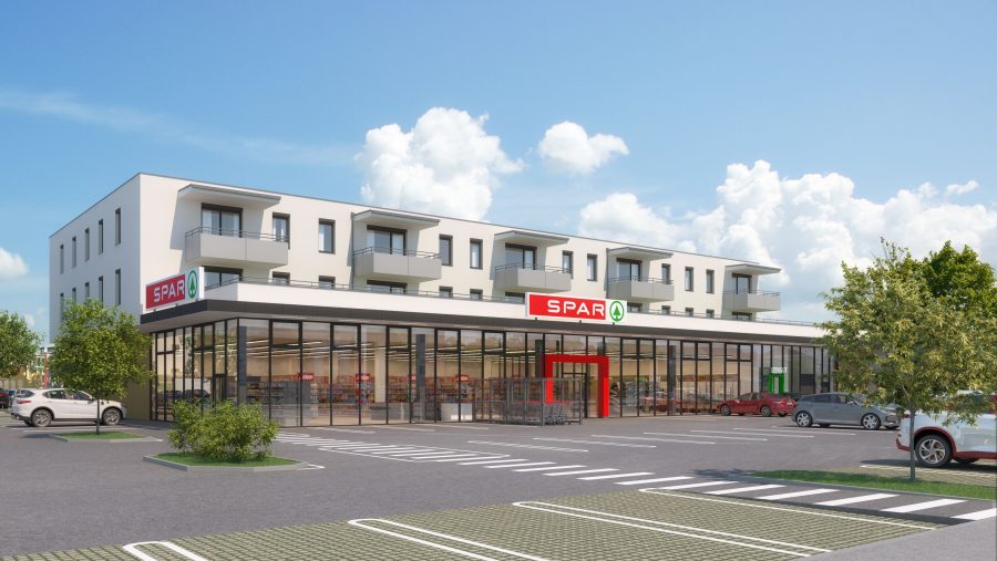Moderne SPAR-Supermarkt mit Parkplätzen und Wohngebäude im Hintergrund an einem sonnigen Tag.