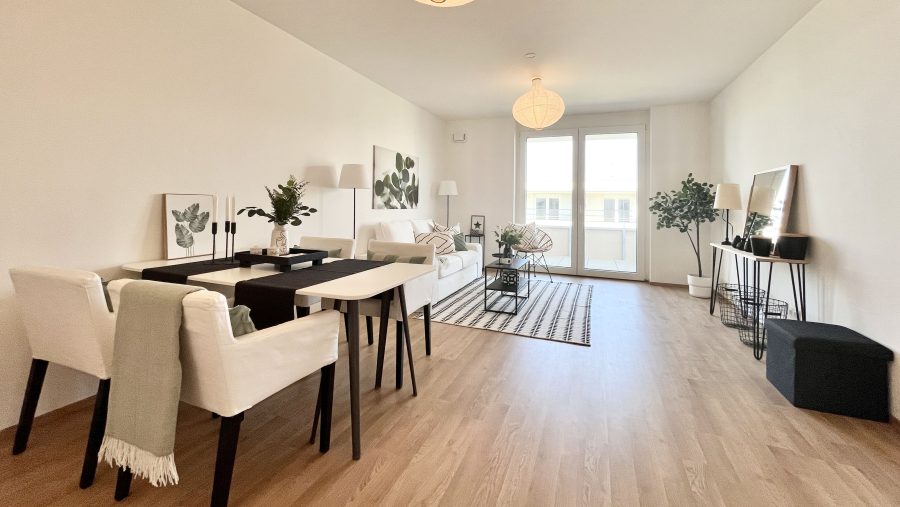 Helles Wohnzimmer mit moderner Einrichtung, Holzboden und großen Fenstern. Elegantes Design mit Pflanzen und Kunstwerken.