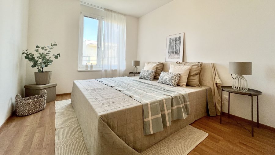 Modernes Schlafzimmer mit großem Bett, hellen Farben und minimalistischem Dekor.