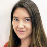 Professionelle Immobilienmaklerin mit langen, braunen Haaren.