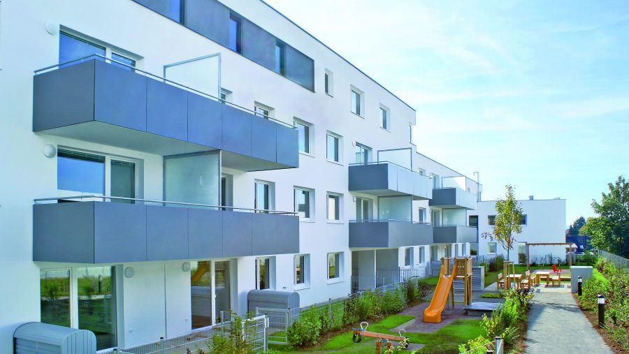 Mehrfamilienhaus mit Balkonen und Spielplatz, ideal für Familien.