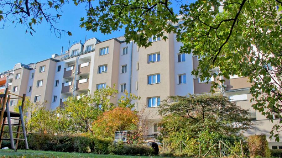 Mehrfamilienhaus im Grünen an einem sonnigen Herbsttag.