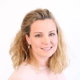 Eine Frau lächelt freundlich in die Kamera.