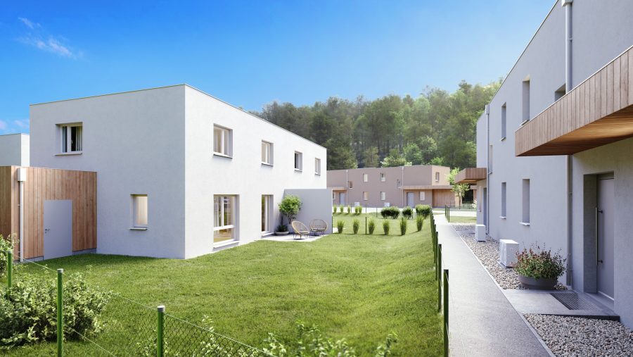 Moderne Wohnsiedlung mit Rasenflächen und Gebäuden bei sonnigem Himmel.