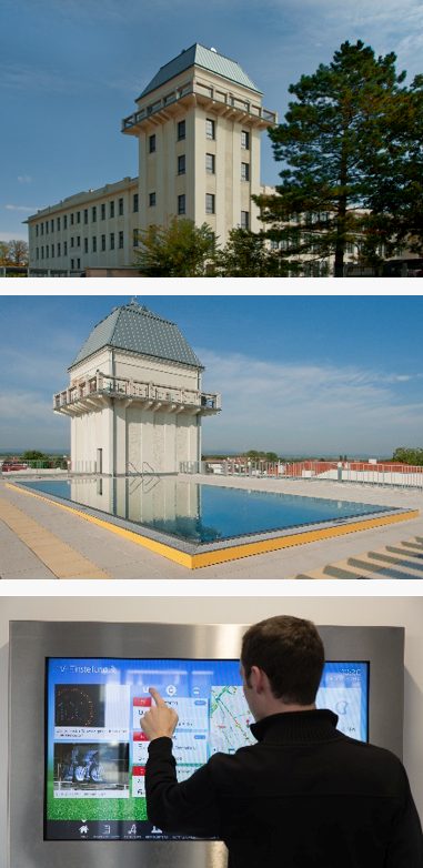 Referenz Teesdorf Ein großes Gebäude mit Swimmingpool auf dem Dach und ein Mann, der einen interaktiven Bildschirm bedient.