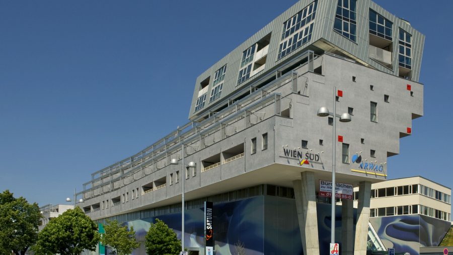 Modernes multifunktionales Gebäude mit auffälliger Architektur unter blauem Himmel.