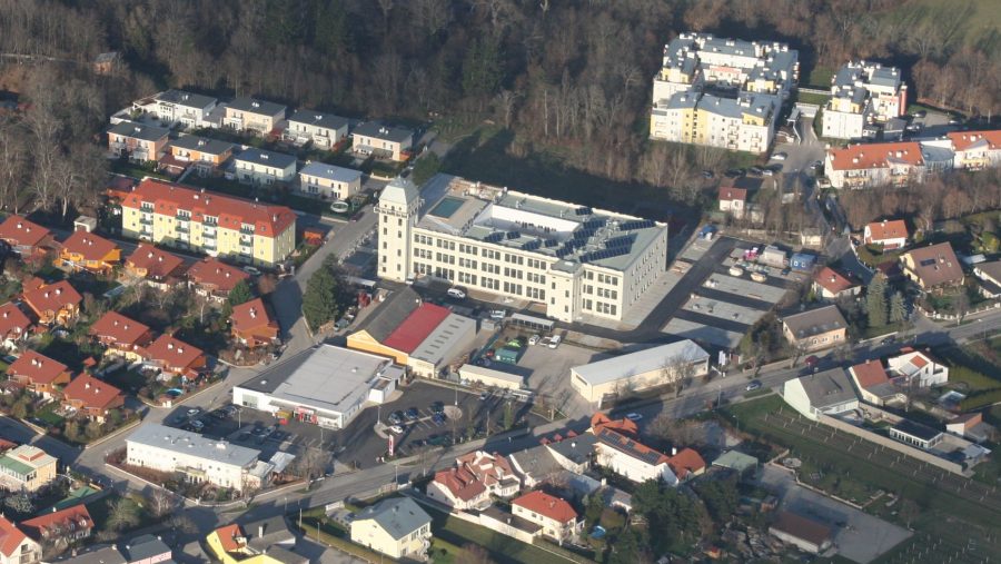 Luftaufnahme einer Wohngegend mit modernen Immobilien und einem Geschäftszentrum in der Nähe. Ideal für Wohnungskäufer.