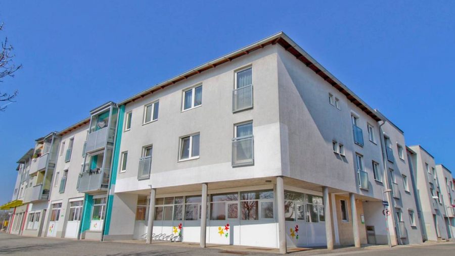 Moderne Wohnanlage mit blauen Akzenten unter klarem Himmel.