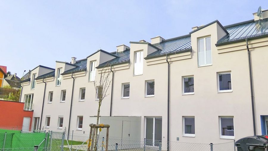 Reihenhäuser mit modernem Design, aufgenommen an einem klaren Tag.