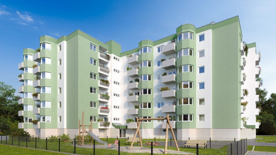 Mehrstöckiges Wohngebäude mit grün-weißer Fassade und Spielplatz im Vordergrund.