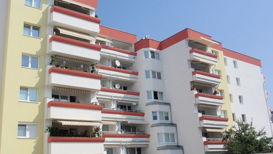 Mehrstöckiges Wohngebäude mit Balkonen an einem sonnigen Tag.