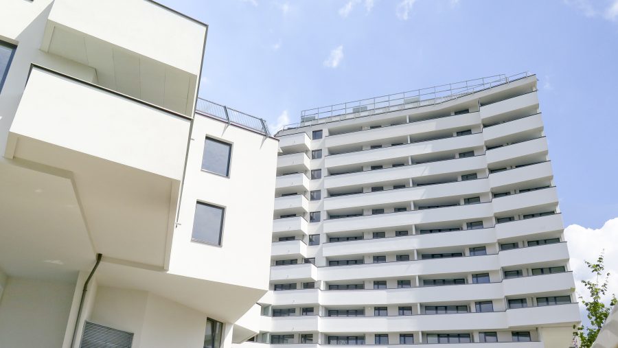 Moderne Wohngebäude mit Balkonen vor blauem Himmel.